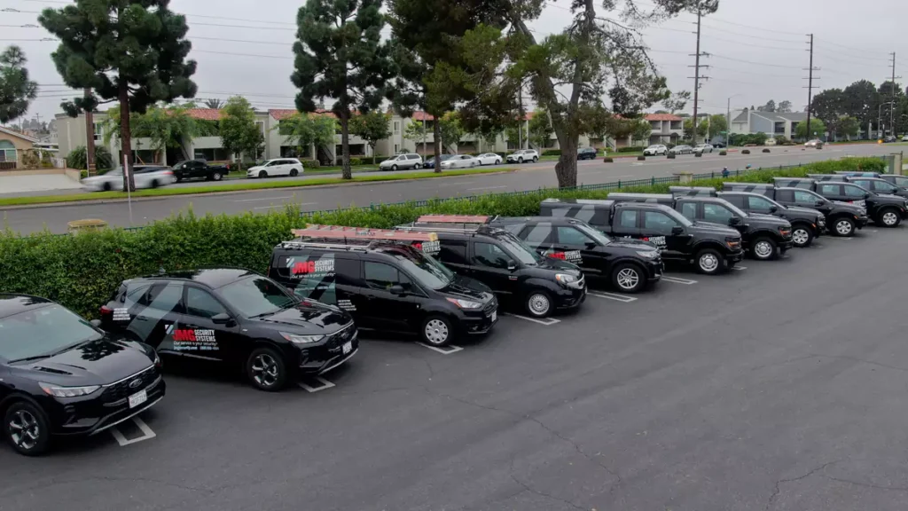 JMG Security Systems fleet of black branded vans and SUVs parked in a row