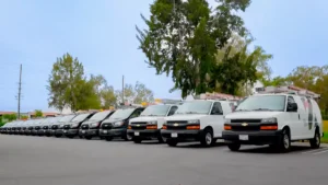 JMG Security Systems white and grey service vans lined up in a parking lot