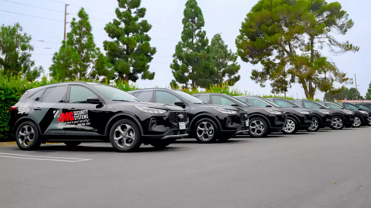 Black JMG Security Systems branded SUVs parked in a row