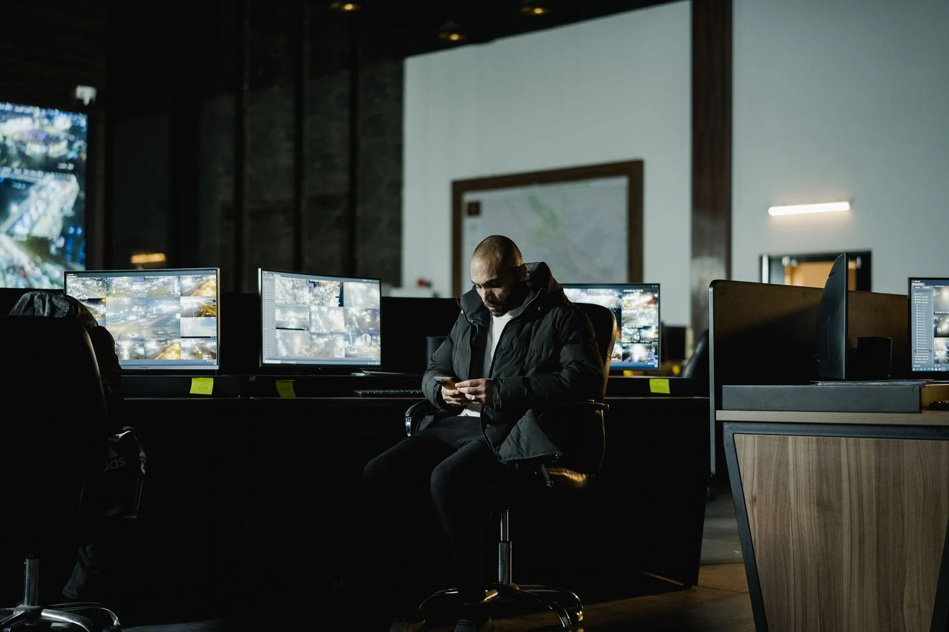 Security officer in dark control room with monitors