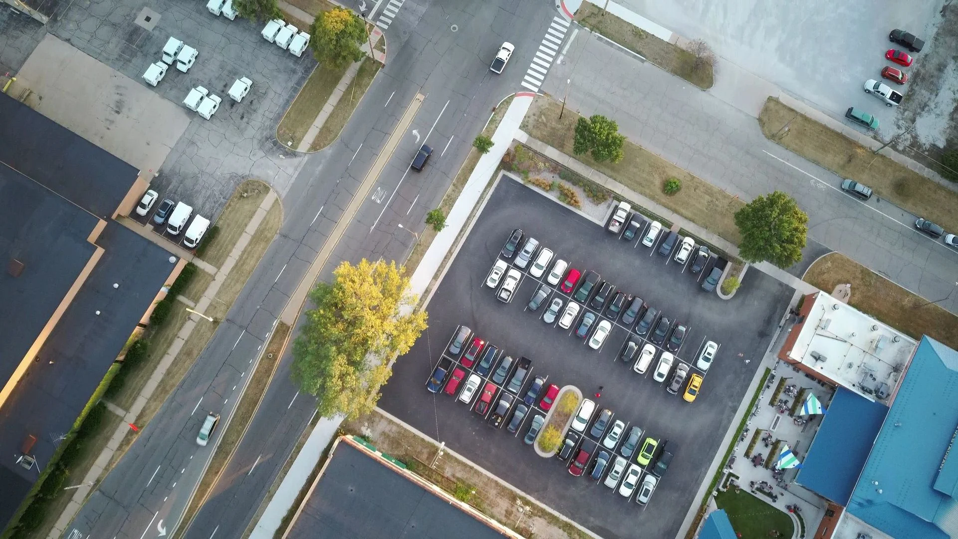 Drone shot of an urban parking lot and surrounding roads at daytime